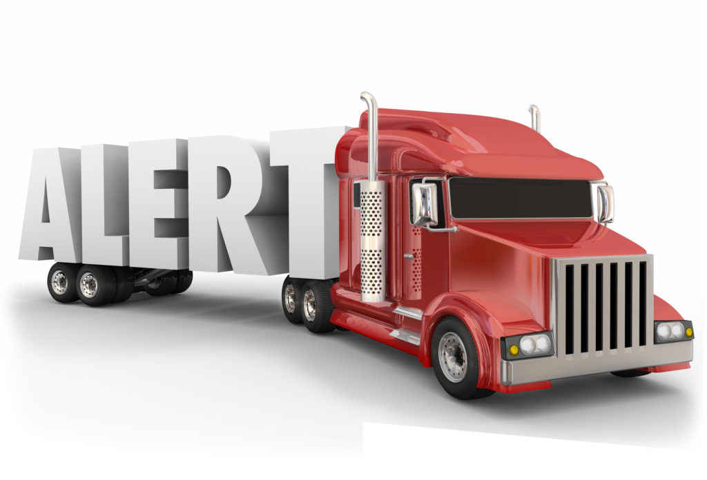 Alert word in 3d letters hauled by a truck to illustrate safe driving and transportation on the road