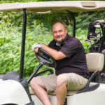 2018 FCC Annual Golf Tournament participant in cart, enjoying day
