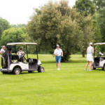 2018 FCC Annual Golf Tournament golfers on fairway near their carts