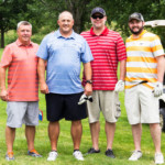 2018 FCC Annual Golf Tournament participants posing happily near cart
