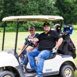 2018 FCC Annual Golf Tournament participants having fun, smiling in cart