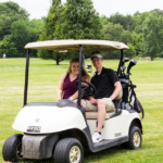 2018 FCC Annual Golf Tournament participants pose and smile in cart